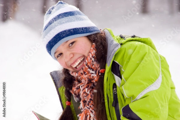 Obraz Laughing beautiful girl snowboarder, snowfall
