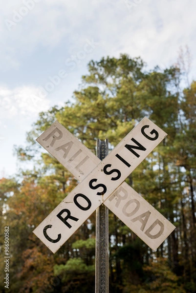 Fototapeta Railroad Crossing sign with trees in background