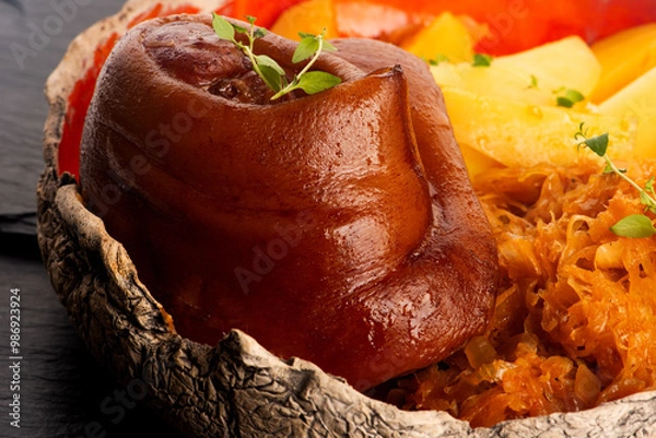 Fototapeta Appetizing baked pork knuckle with potatoes and cabbage on plate