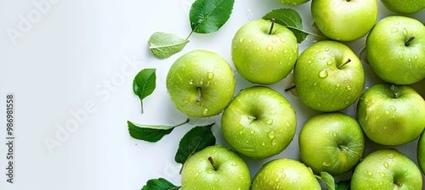 Fototapeta many fresh green apples and green leaves on white background, top view