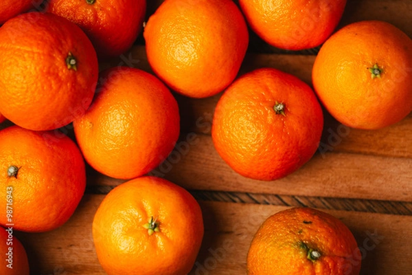 Obraz many fresh tangerines on a wooden background