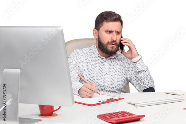 Fototapeta Portrait of businessman talking on mobile phone in office