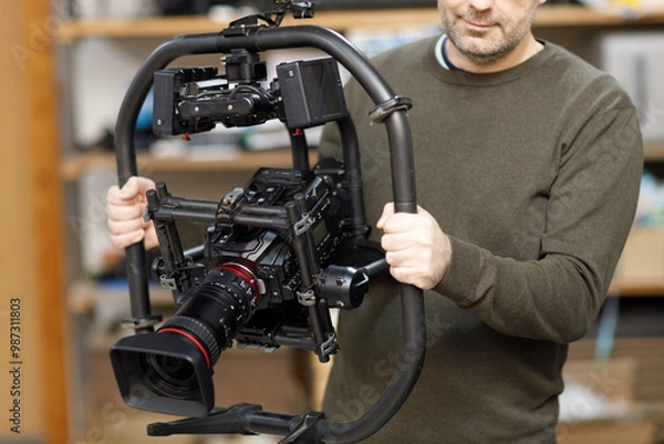 Fototapeta Professional videographer holding camera on gimbal rig steadycam to make video without shaking
