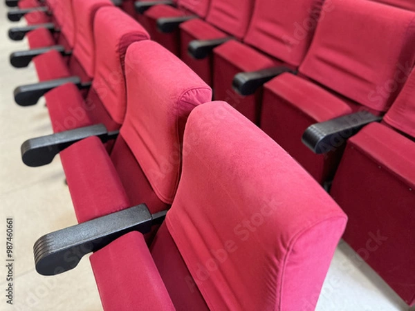 Obraz A close-up view of rows of chairs upholstered in red velvet.