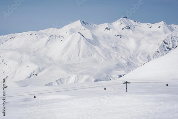 Fototapeta Snowy slopes with gondola to Kobi and ski tracks in nice sunny day. Ski resort Gudauri, Georgia. Caucasus Mountains. Aerial view.
