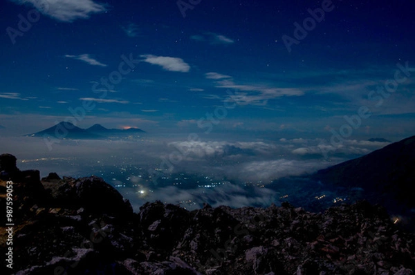 Fototapeta Night view of the Mount Merbabu National Park with the light of the city on the valley