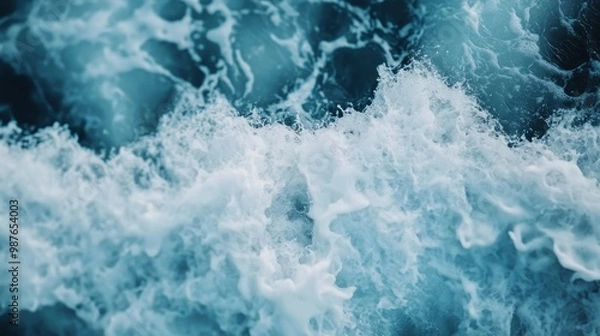 Fototapeta An aerial shot of turbulent ocean waves crashing with white foam against the shoreline, depicting the raw power and beauty of the sea in motion, in vivid detail.