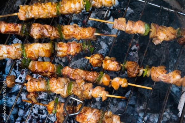 Fototapeta barbecue in the garden at home with chicken skewers overhead shot