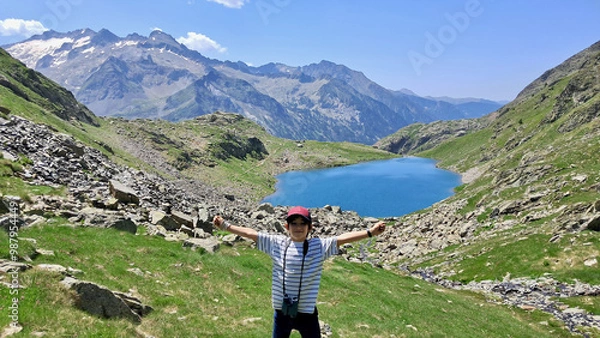 Fototapeta Joyful little kid portrait with Gorgutes lake and snowy Pyrenees mountains on background on a sunny summer day, Benasque, Spain.
