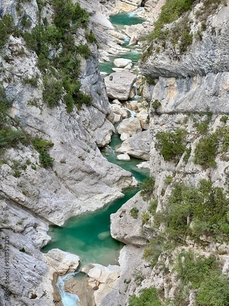 Fototapeta Un canyon spectaculaire dans les Alpes françaises, avec des parois rocheuses abruptes et de l'eau bleu clair qui serpente au fond.