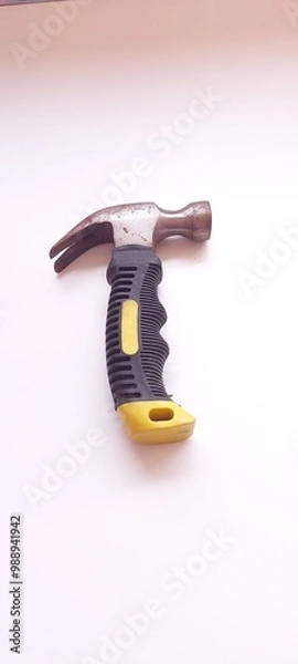 Fototapeta A small hammer with a black rubber handle, on a white background