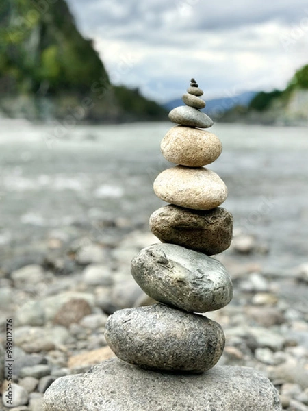 Obraz Round stones are set on top of each other against the background of a river and a mountain landscape. Altai, Russia. A conceptual symbol of natural balance.