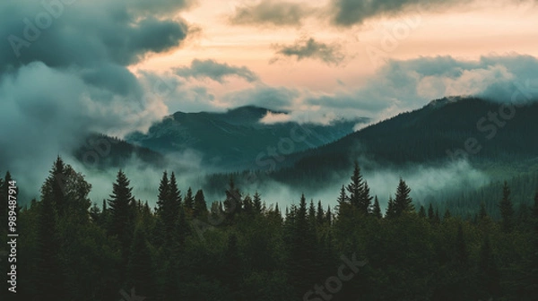 Obraz Misty mountain landscape with dark pine trees in the foreground, as clouds roll over the hills at dawn, creating a serene and mystical atmosphere