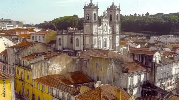 Fototapeta A view of an old European city with a prominent church rising above the surrounding buildings, characterized by weathered facades and terracotta rooftops.