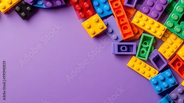 Fototapeta Colorful building blocks scattered on a purple background.
