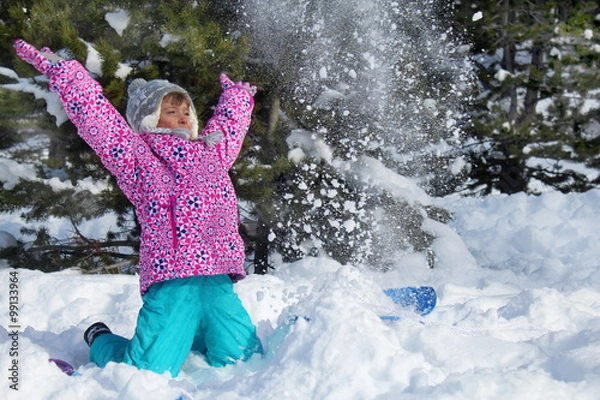 Obraz Happy snowy holidays. Picture of a little girl playing with snow in a mountain forest
