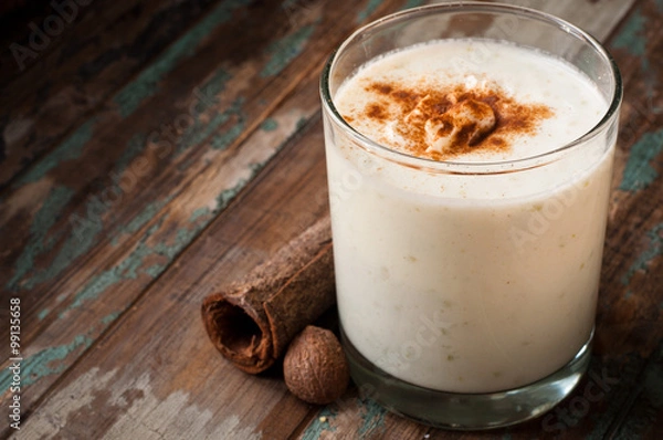 Obraz Apple crumble smoothie milkshake topped with cinnamon and nutmeg spices. Served on a rustic wooden table.