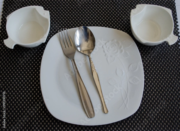 Fototapeta empty plate and cutlery set on a table