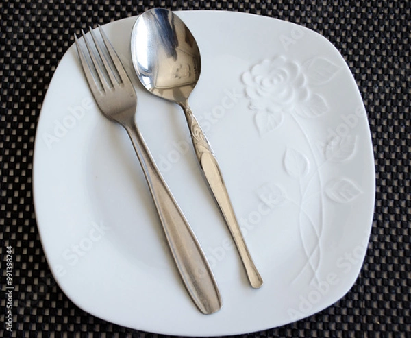 Fototapeta empty plate and cutlery set on a table
