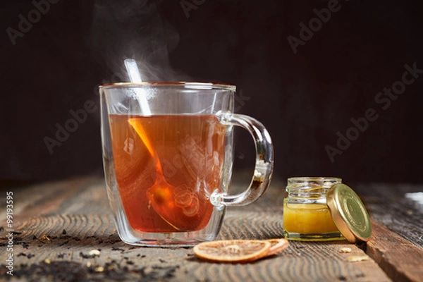Fototapeta Steaming tea and honey on a wooden table