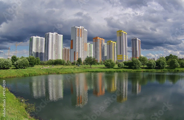 Fototapeta Городской пейзаж новостроек в парке с водоёмом.
