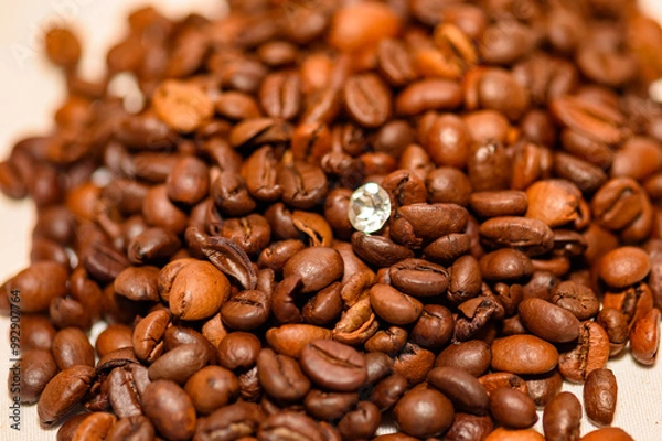 Fototapeta A pile of coffee beans spilled on the table