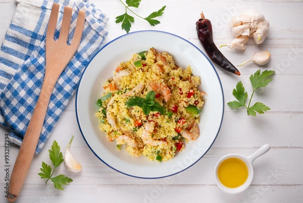 Fototapeta Couscous salad with vegetables and prawns. Top view table with  decoration.