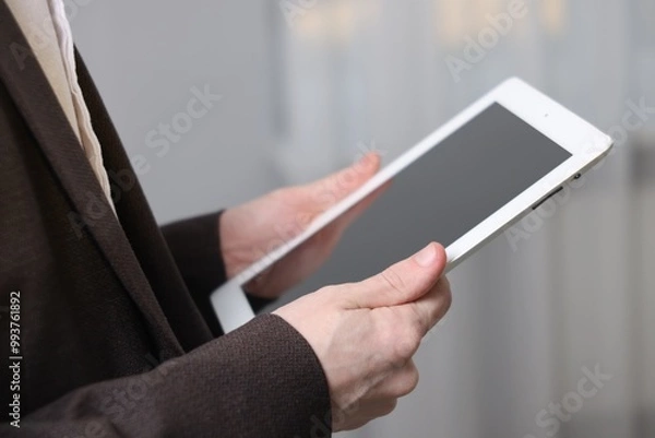 Fototapeta Businessman using tablet indoors, closeup. Modern technology