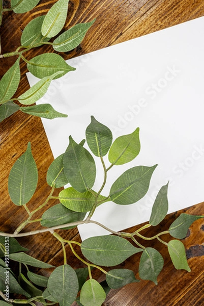 Fototapeta white sheet of paper on wooden background with leaves