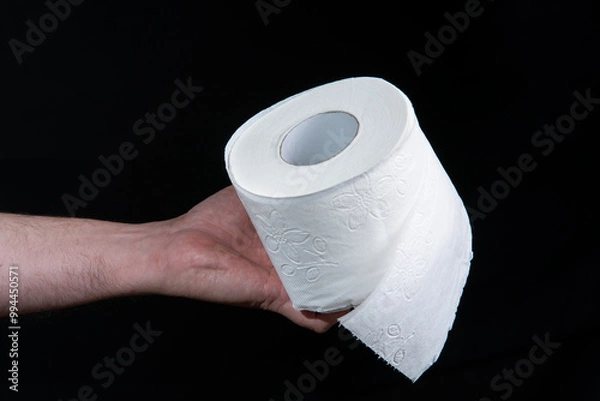 Obraz Close-up of a man's hand holding a roll of white toilet paper