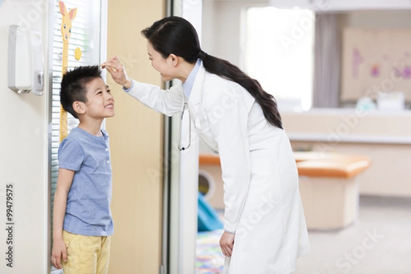 Obraz Doctor measuring boy's height
