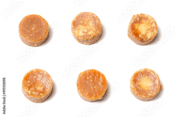 Fototapeta A neatly arranged of traditional brown sugar (gula jawa) cylindrical blocks isolated on a clean white background. The rich, caramel color contrasts beautifully with the crisp, minimalist backdrop