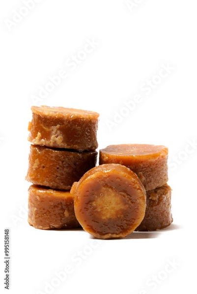 Fototapeta A neatly arranged of traditional brown sugar (gula jawa) cylindrical blocks isolated on a clean white background. The rich, caramel color contrasts beautifully with the crisp, minimalist backdrop