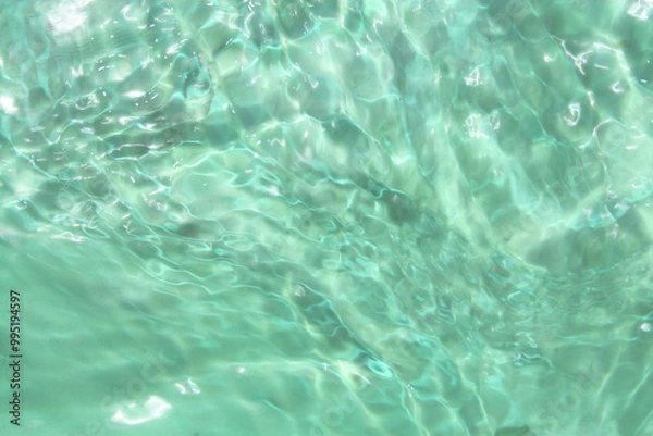 Fototapeta Defocus blurred transparent green colored clear calm water surface texture with splashes and bubbles. Trendy abstract nature background. Water waves in sunlight with copy space. Green water shine
