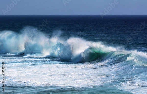 Fototapeta Coastal seascape with powerful waves crashing against the shore