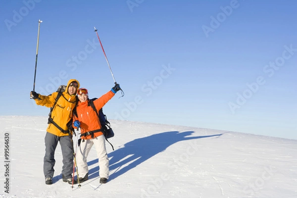 Obraz Two young people with their ski poles in the air