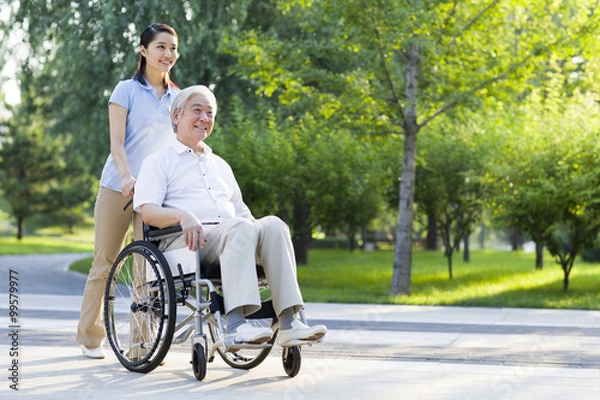 Obraz Wheelchair bound man with nursing assistant