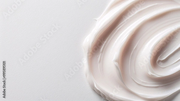 Fototapeta Close-up of a smooth, creamy swirl of lotion on a white background.