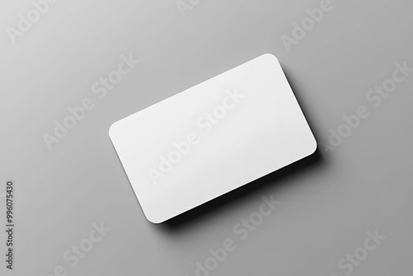 Fototapeta A mockup of a blank business card on a gray background, close-up, top view, with a soft shadow. Created with Ai