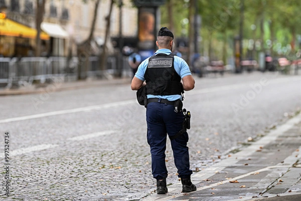 Fototapeta Illustration picture showing a male police officer (man) with uniform from gendarmerie ensuring security in Paris, France. French national policeman in action.