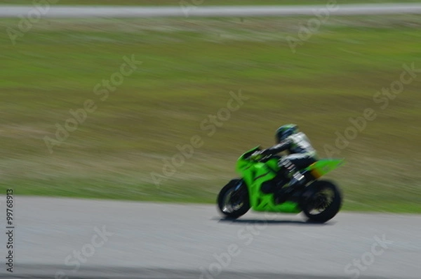 Fototapeta Blurred athletes practicing racing motorcycles on the race track