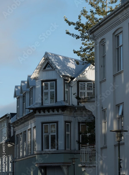 Obraz Row of traditional white painted houses in northern part of downtown, with sun highlights and wooded ornament details in exterior