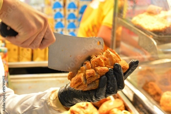 Fototapeta The chef is chopping up crispy fried pork legs.