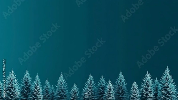 Fototapeta Row of snow-covered pine trees against a deep blue gradient sky