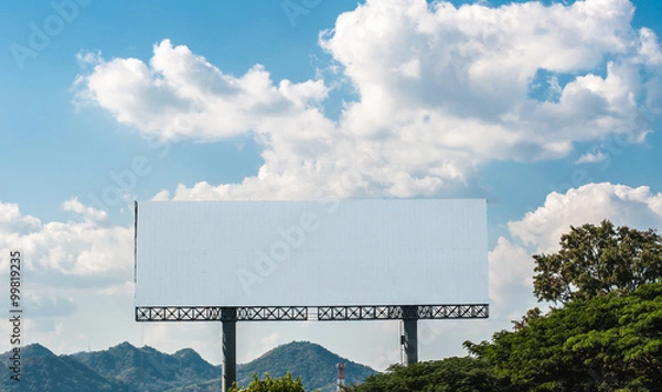 Obraz Blank billboard against white cloud and blue sky in forest