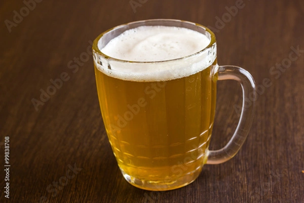 Fototapeta Mug of beer on wooden background