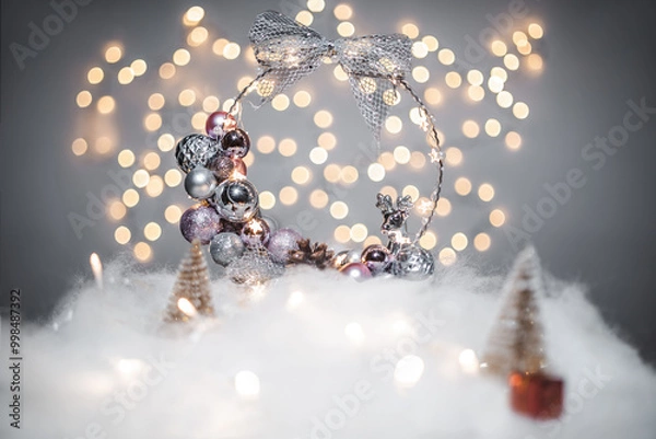 Fototapeta Christmas deoration concept on holidays with a silver derr, white fake snow for a festive december. In the background are bokeh balls made of lights