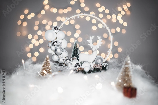 Fototapeta Christmas deoration concept on holidays with a porcelain derr, white fake snow for a festive december. In the background are bokeh balls made of lights