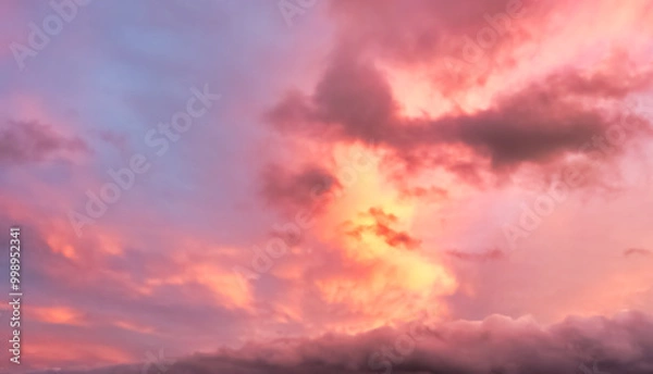Fototapeta A beautiful sky tinted by the sun leaving vibrant shades of gold, pink, blue and multicolored. Clouds in the twilight evening and morning sky. Cloudy sky background in the evening, and during the day.