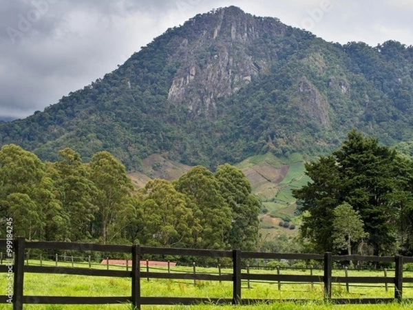 Fototapeta Mountains with a fence and pasture in the foreground